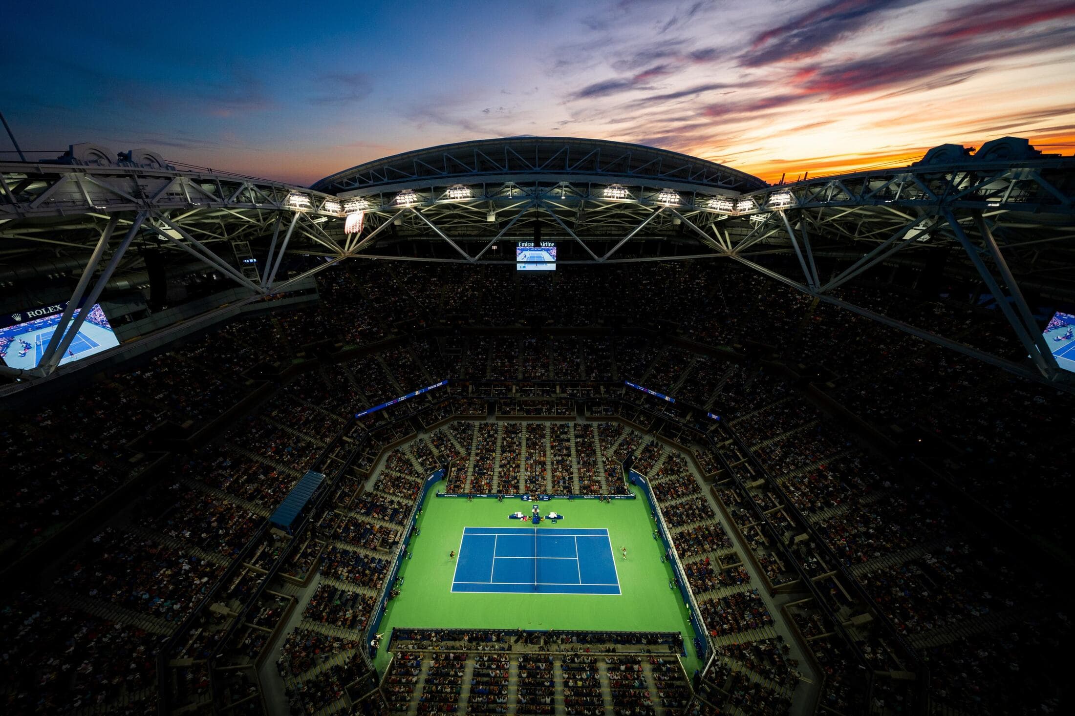 Sold-out tennis stadium at sunset